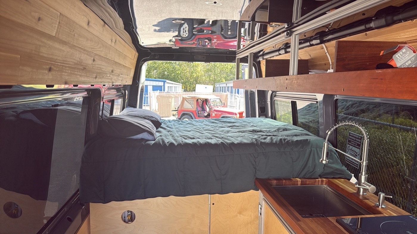 Full-size rear sleeping platform with teal bedding