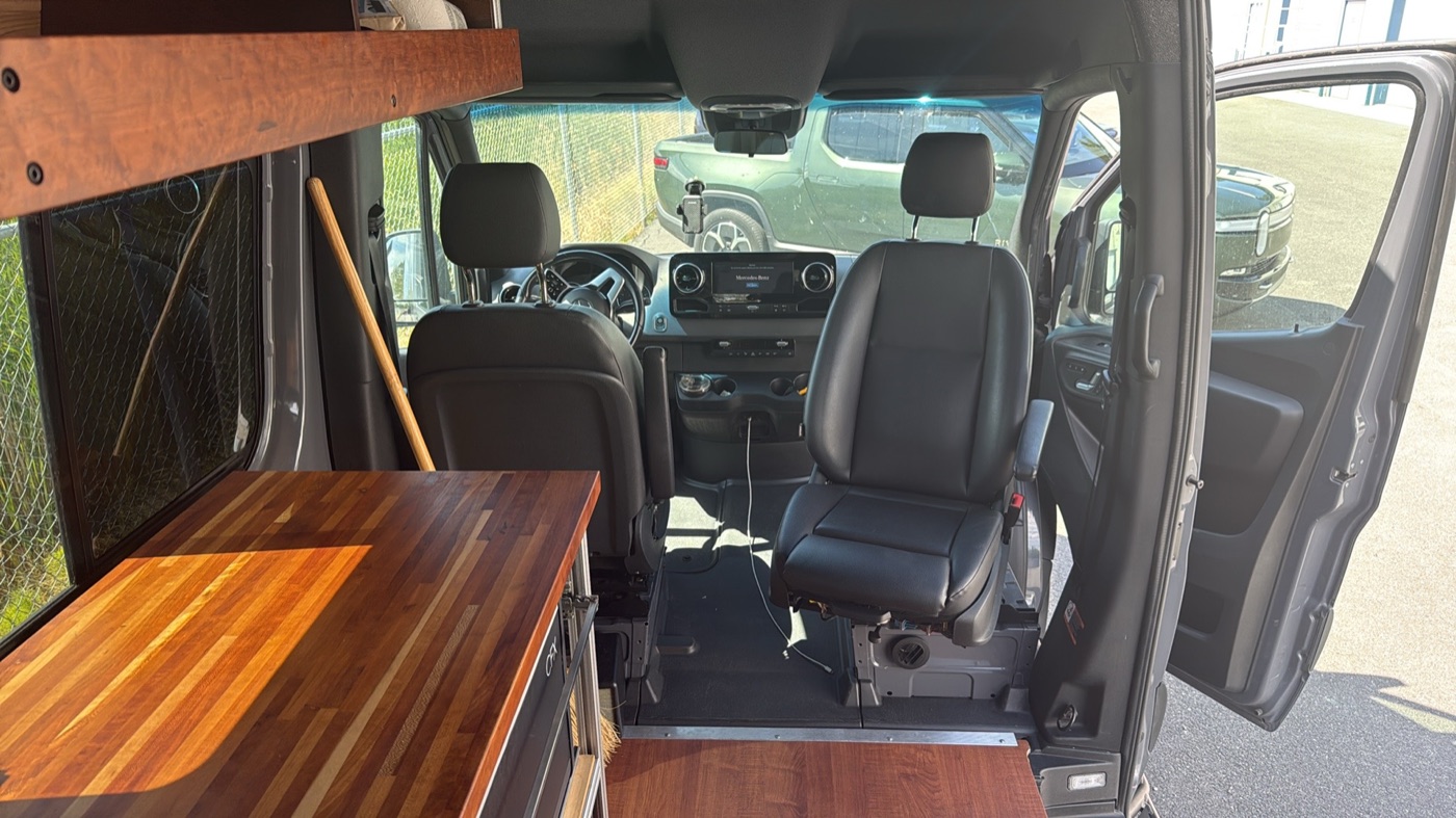 Driver cab with swivel captain's chairs and pass-through