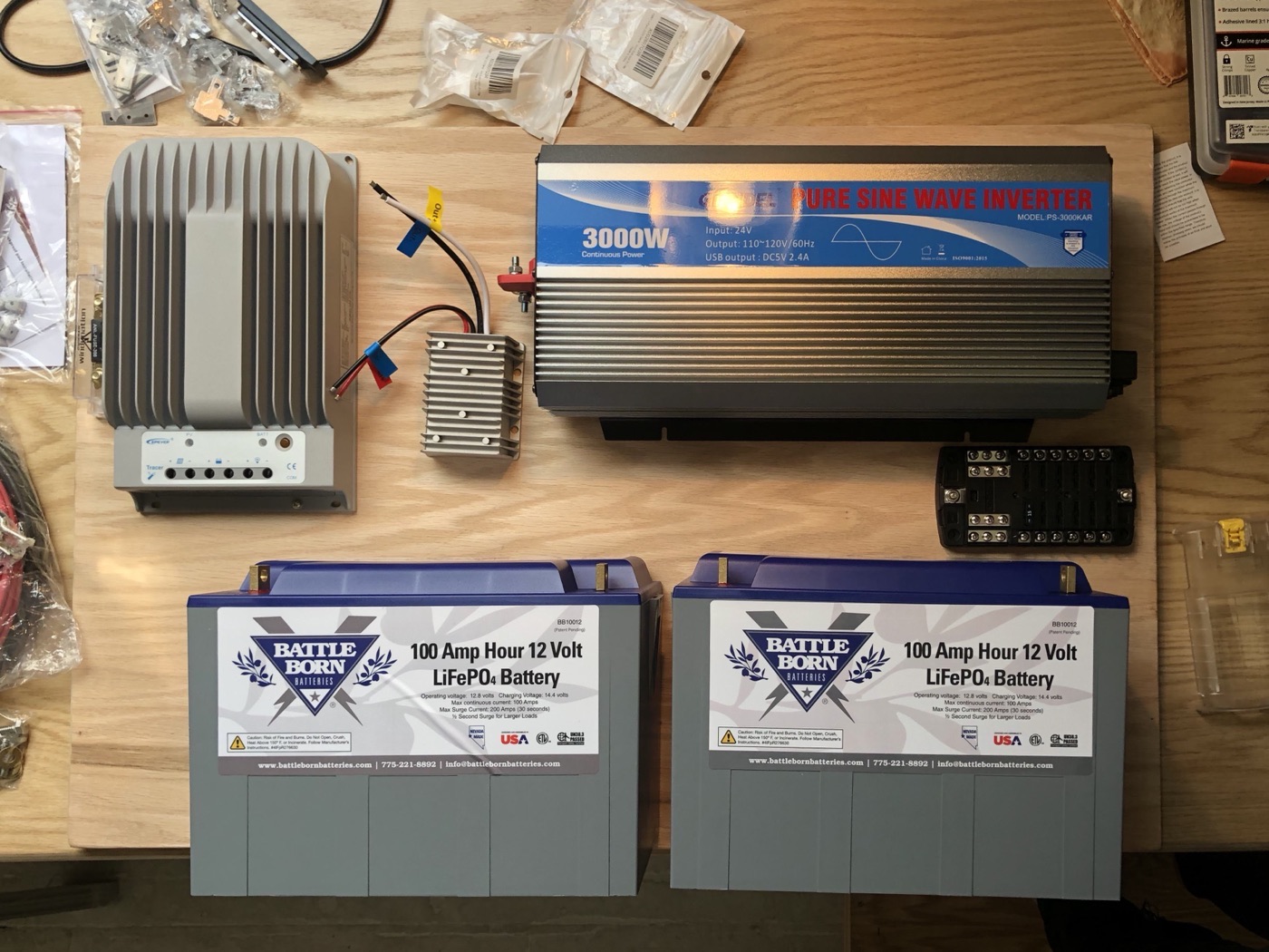 Battle Born LiFePO4 batteries, 3000W pure sine inverter, and MPPT charge controller laid out before installation