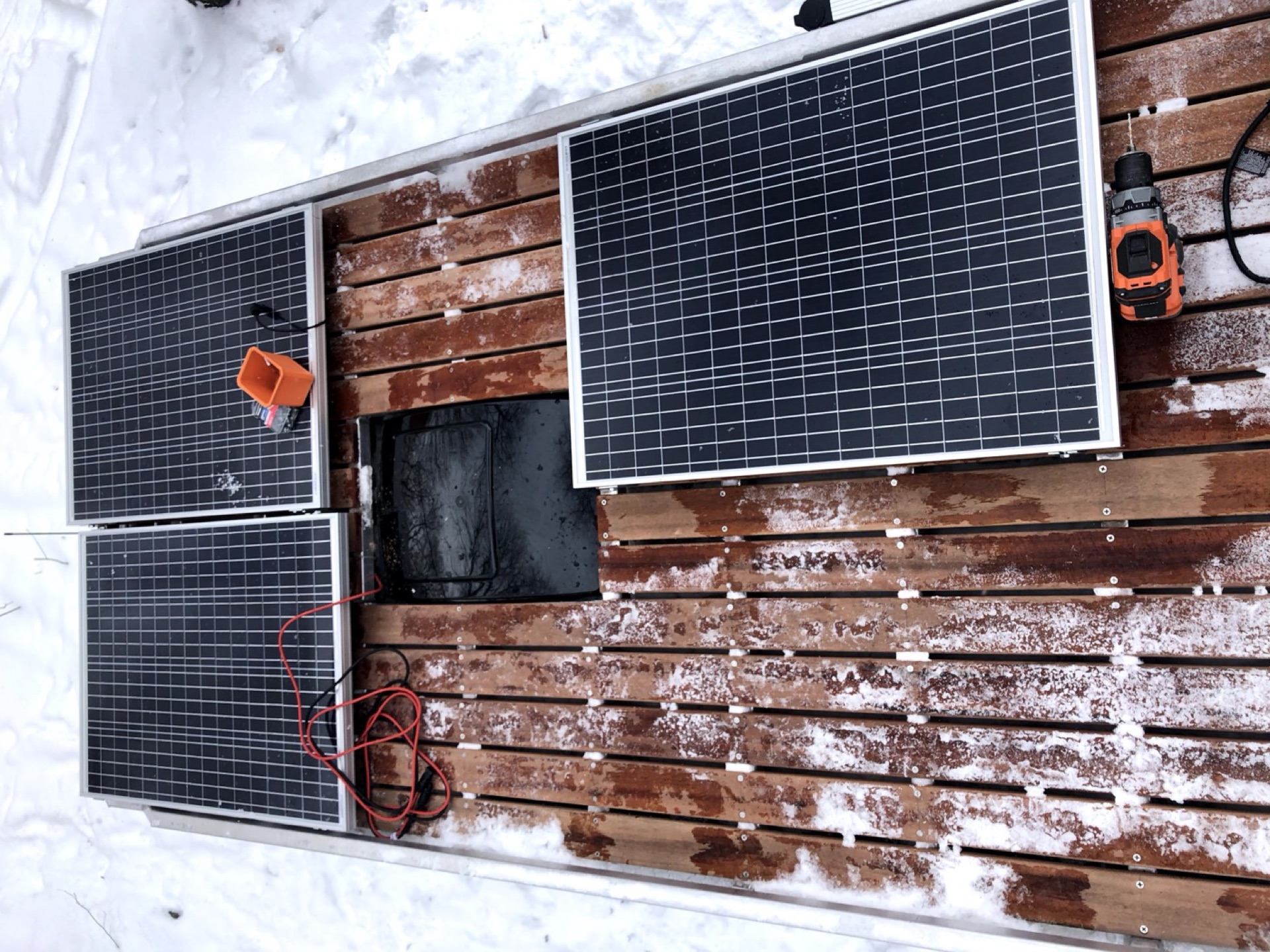Four solar panels on the Tigerwood roof deck, overhead view in winter snow